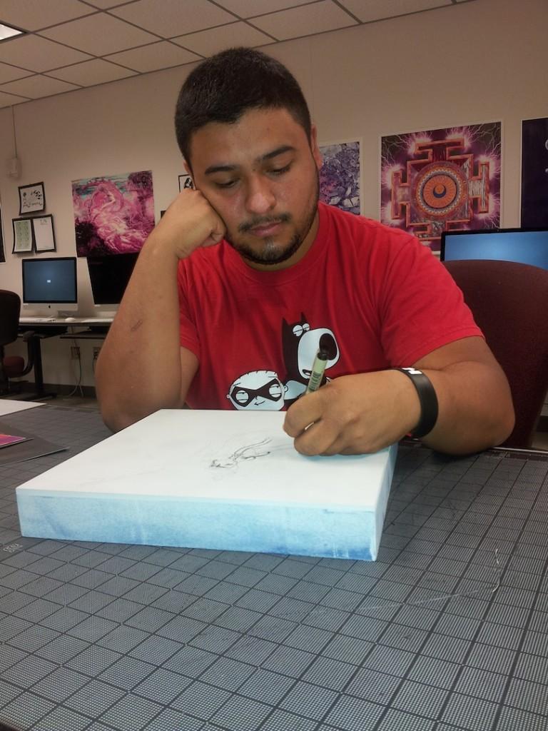 San Jac student Christopher Gaviria works on a watercolor piece for the 12x12 Mentor 2013 exhibition 
