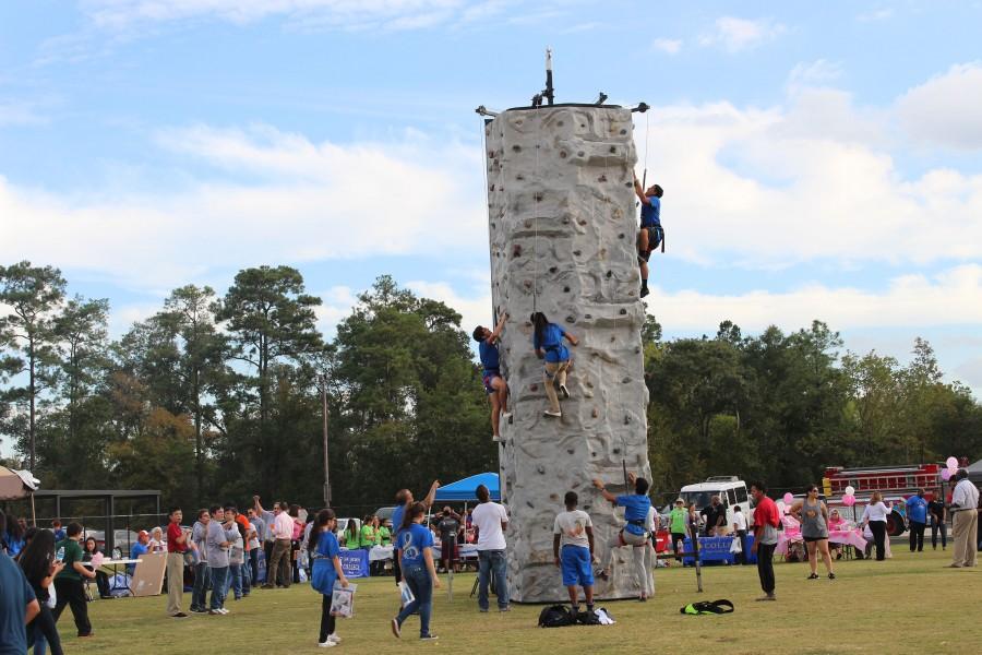 Potential North campus students scale the rock climbing wall at C.E. King Middle School while learning about educational options.