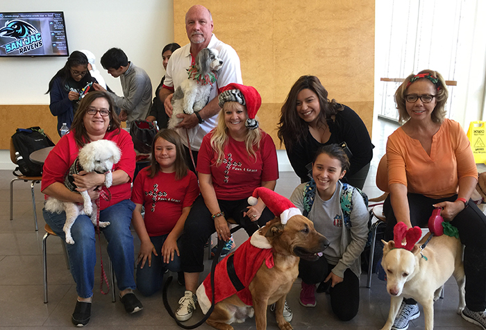 Rec Sports Director Butch Sutton (standing) holds his certified therapy dog, Mia, while posing with fellow Paws 4 Grace members and their service animals during a visit to Central Campus on Dec. 3, 2017.