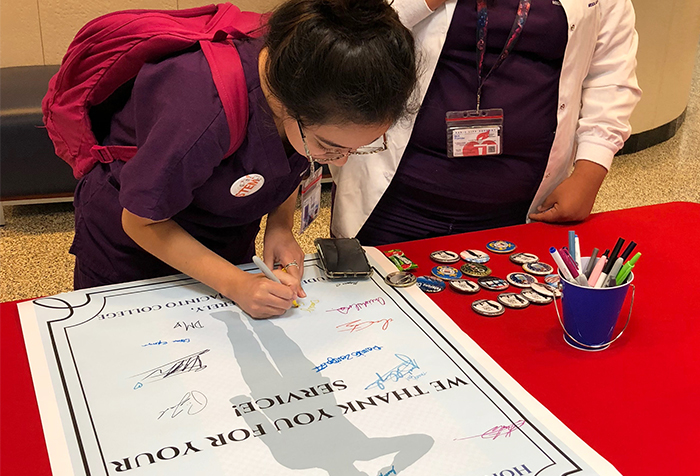 Daisy Saucedo writes a message of appreciation to the men and women who served in the United States armed forces during the Veterans Celebration Kickoff Nov. 5 on the North Campus.